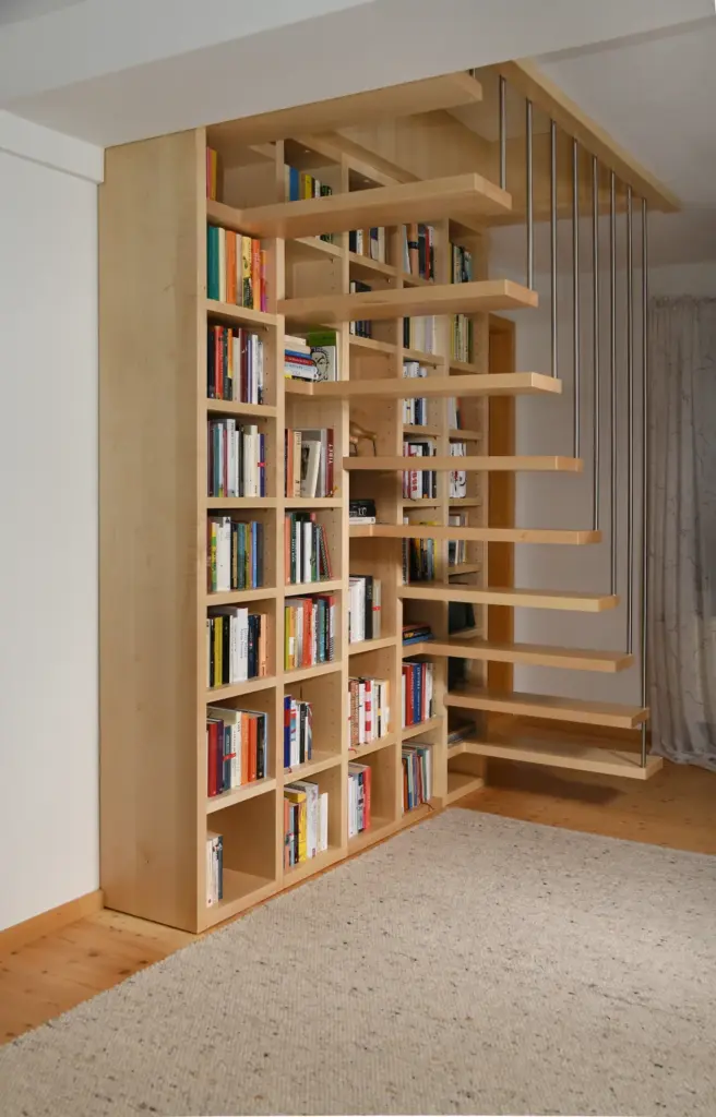 Eine moderne Holztreppe mit offenen Setzstufen ist in ein mit Büchern gefülltes Einbauregal integriert. So entsteht ein platzsparendes Design in einem Raum mit hellem Holzfußboden und einem beigefarbenen Strukturteppich.
